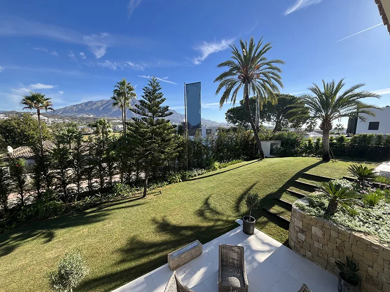 Lawn, palms and open views in a Nueva Andalucía garden